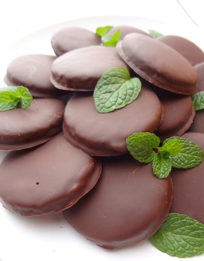 Top angle of vegan thin mints on a white plate. Chocolate Almond Cookies covered in a mint chocolate